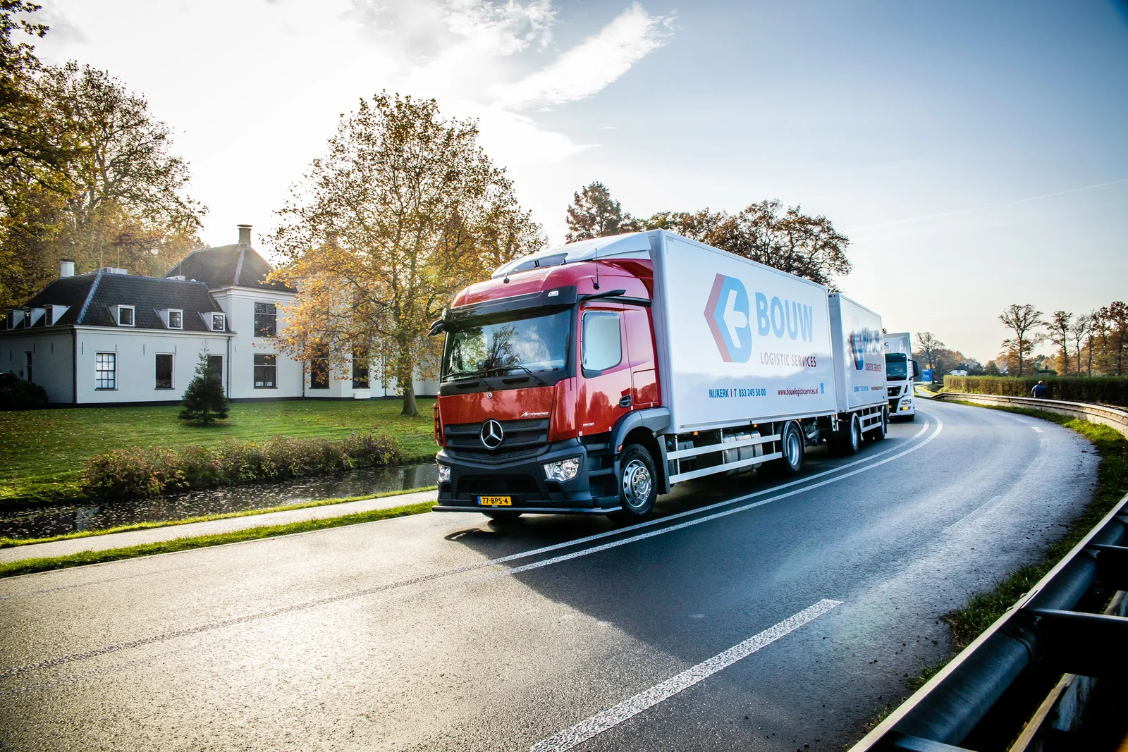 Een rode Bouw-vrachtwagen onderweg voor transport en distributie