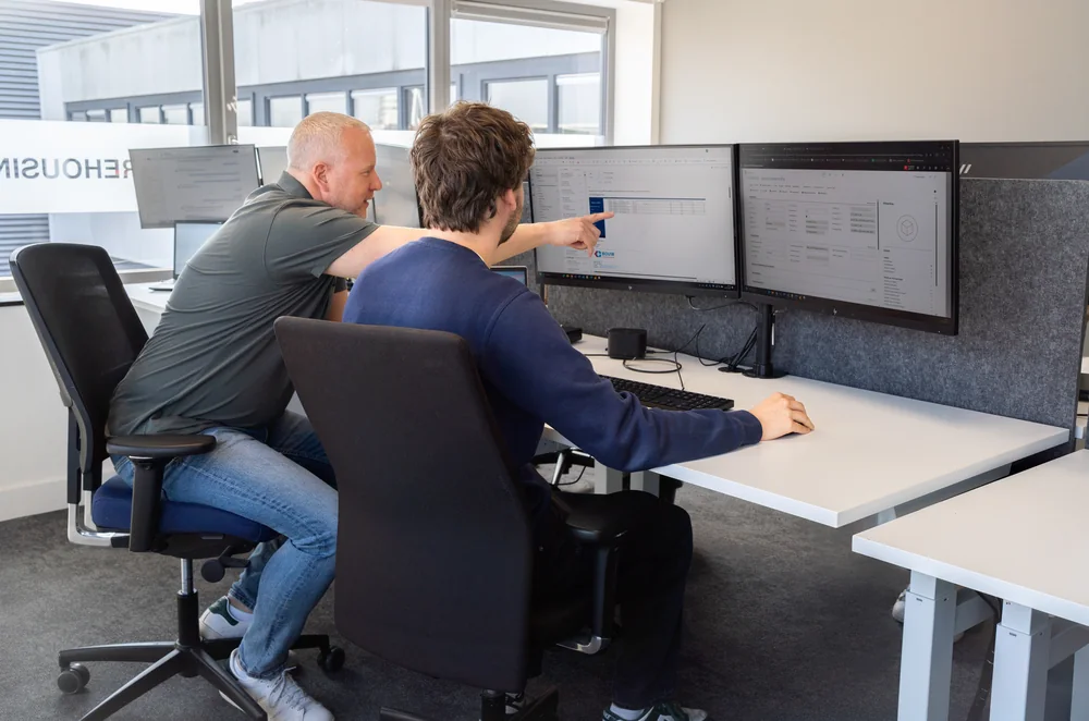 Medewerkers bekijken de logistieke planning op beeldschermen